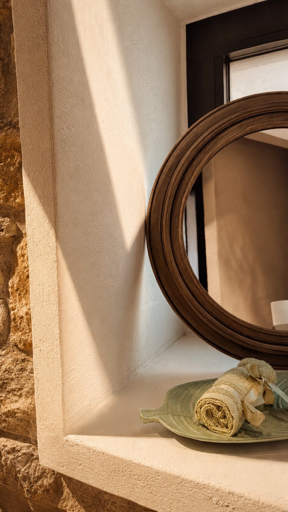 Round mirror set into a stone niche